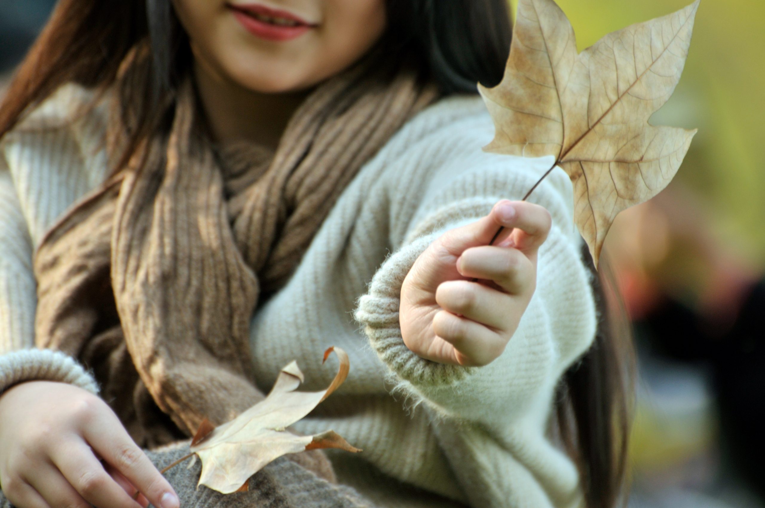 a young girl holding a leaf