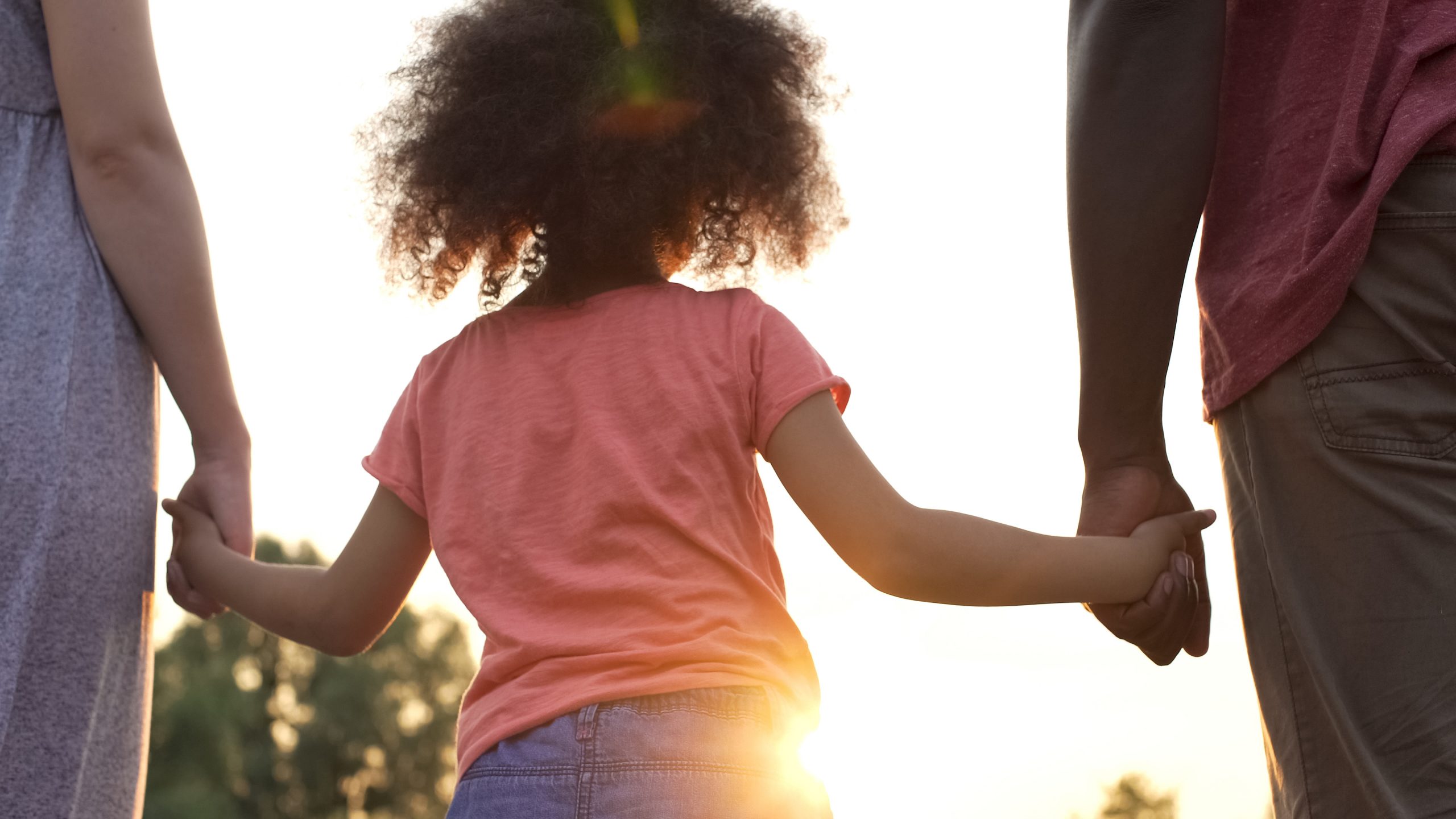 Little girl holds fathers and mothers hands, happiness and wellb a young girl holding a leaf