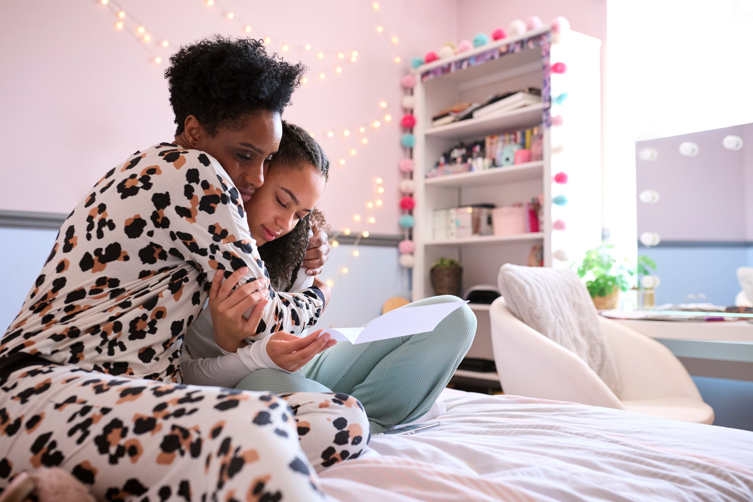 Mother Comforting Teenage Daughter In Bedroom Looking At Letter With Disappointing Exam Results a young girl holding a leaf