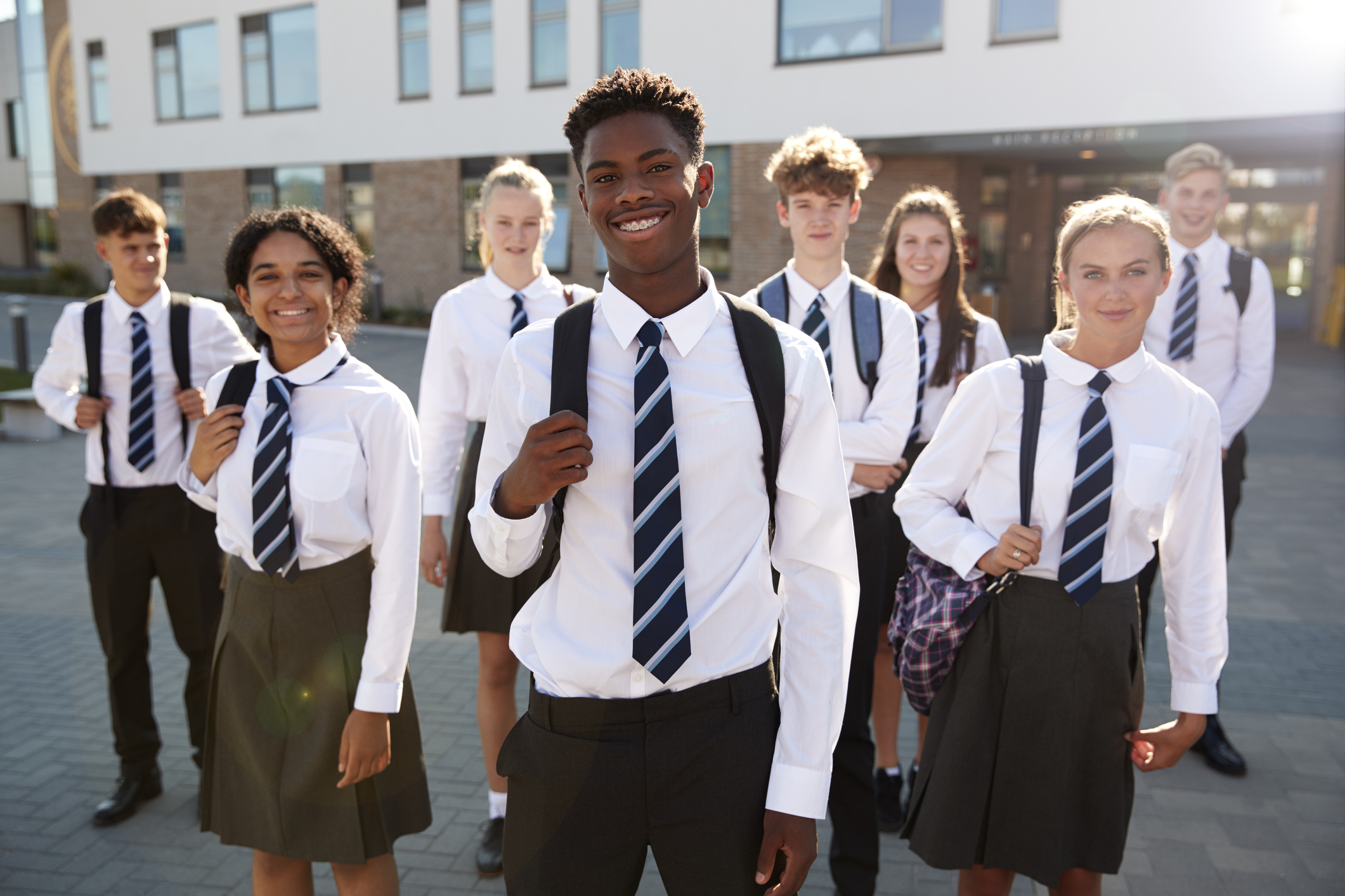 Portrait Of Smiling Male And Female High School Students Wearing Uniform Outside College Building
