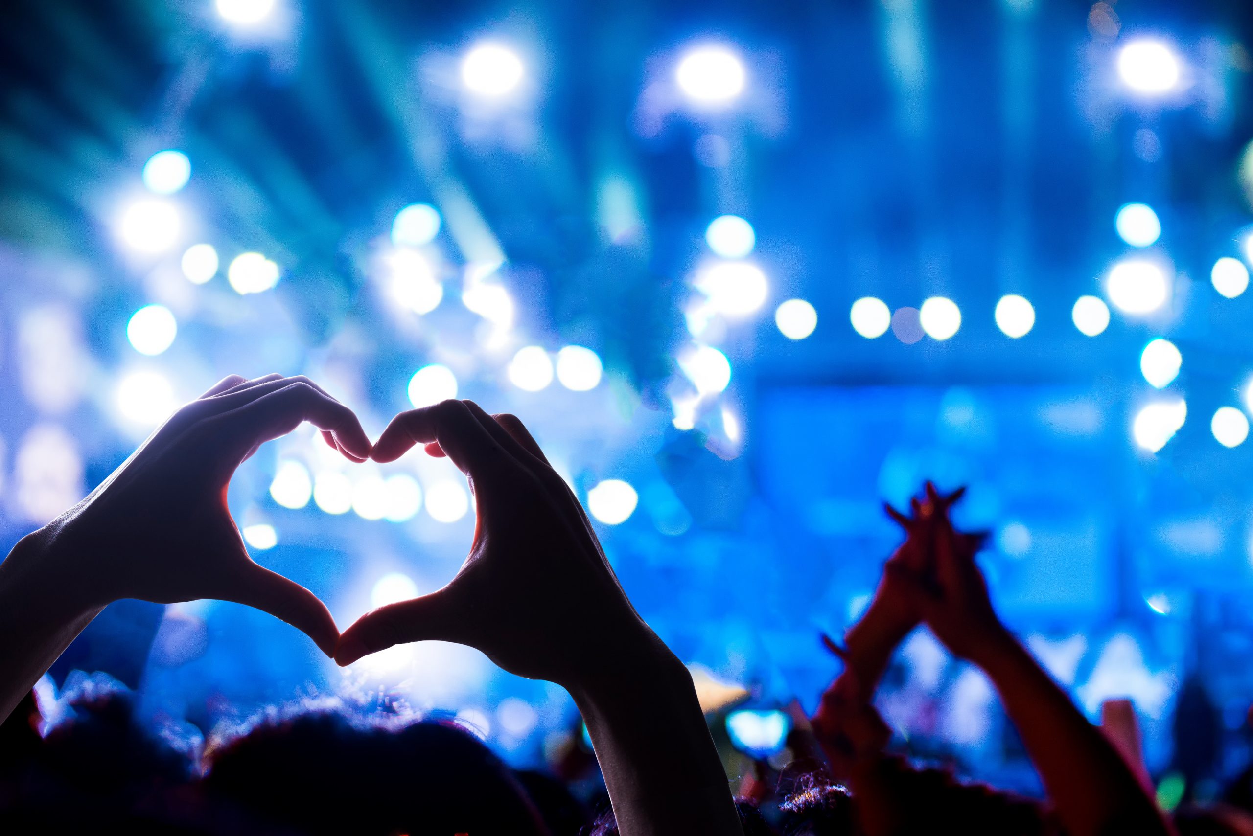 Crowd of Audience at during a concert with silhouette of a heart